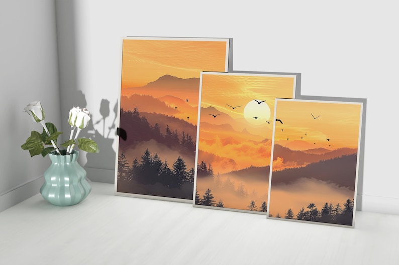 Puede incluir: Tres impresiones art&iacute;sticas enmarcadas que representan un paisaje monta&ntilde;oso al atardecer. La obra de arte presenta una c&aacute;lida paleta de colores naranjas y marrones, con siluetas de &aacute;rboles y p&aacute;jaros volando. Un jarr&oacute;n con rosas blancas est&aacute; cerca.
