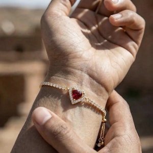 Puede incluir: Una taza de cerámica blanca con un asa negra y el texto "But First, Coffee" en negrita negra. La taza se encuentra sobre un fondo borroso, sugiriendo un ambiente acogedor.