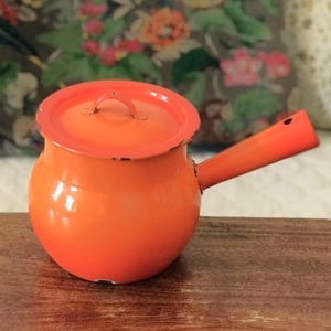 Tall fondue pot or pot made of orange enameled sheet metal with its original lid