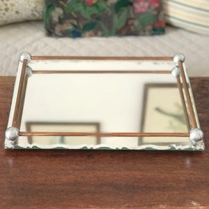 May include: A white ceramic mug with a black handle and the text "But First, Coffee" in a bold, black font. The mug is set against a neutral background, highlighting its simple design.