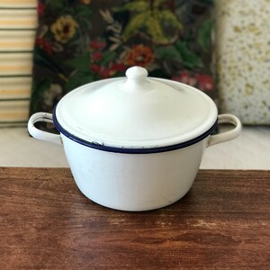 White enamelled metal pot or casserole dish with lid