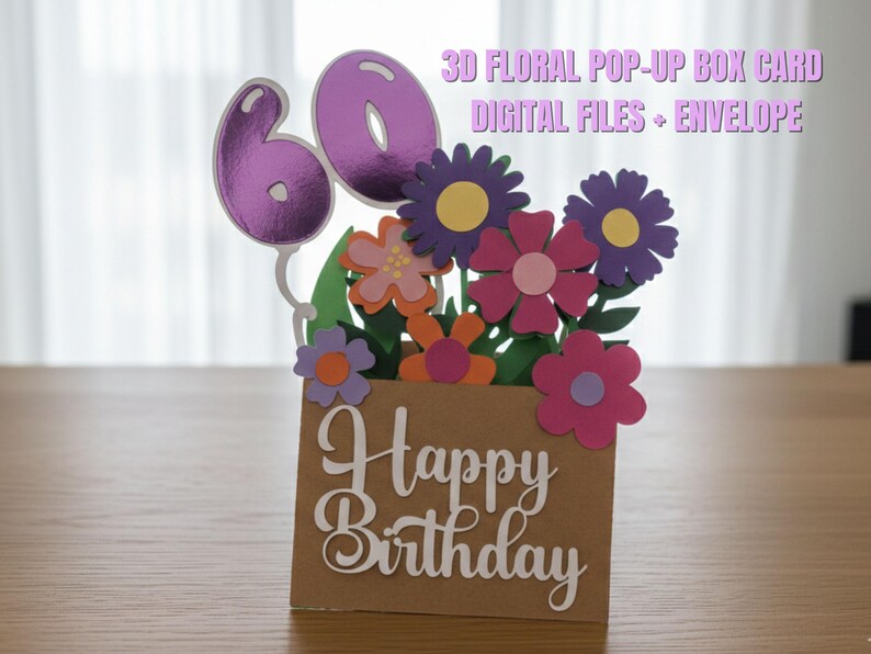 May include: A 3D floral pop-up box card with a brown box base and colorful paper flowers. The card features the number 60 in purple and the words "Happy Birthday" in white script. The text "3D Floral Pop-Up Box Card Digital Files + Envelope" is also visible.
