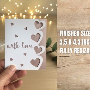 Pu&ograve; includere: Un biglietto bianco con retro rosa, con cuori ritagliati e le parole "with love". Il biglietto misura 8,9 x 10,9 cm. Piccoli cuori sono sparsi sulla superficie del biglietto.