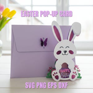 May include: A lilac Easter pop-up card featuring a white rabbit and a butterfly cut-out. The rabbit has pink inner ears and feet, and the card says "Happy Easter". The text "SVG PNG EPS DXF" is also visible.