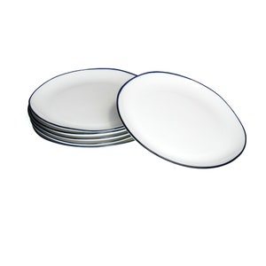 May include: A stack of six white ceramic dinner plates with a thin blue rim.