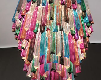 May include: A multi-colored crystal chandelier with long, thin prisms hanging from a central point. The prisms are arranged in a cascading pattern, creating a rainbow effect.