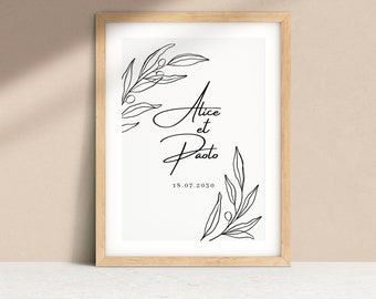 May include: A framed print with a light wood frame. The print features the names "Alice et Paolo" in elegant script, along with the date "18.07.2030". Black line art of olive branches adorns the top left and bottom right corners.