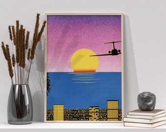 May include: A framed print of a sunset over a city skyline with a plane flying overhead. The sky is a gradient of pink and purple, and the sun is a bright yellow. The city is silhouetted against the horizon, with lights twinkling.