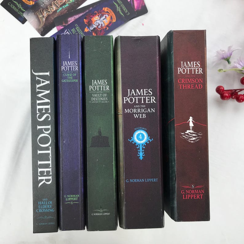 May include: A collection of hardcover books with titles including "James Potter" and "Crimson Thread." The spines are various colors, including green, purple, and brown, with white text. The books are arranged vertically, with decorative bookmarks visible.