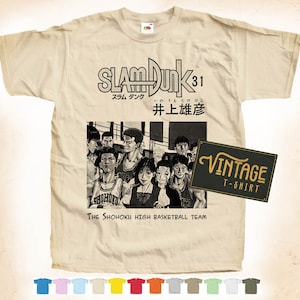 Può includere: Una maglietta vintage beige con un'immagine in bianco e nero della squadra di basket della Shohoku High School della serie anime Slam Dunk. Il testo "SLAM DUNK 31" e "井上雄彦" è stampato sulla maglietta. Il testo "The Shohoku High Basketball Team" è stampato sotto l'immagine. Un'etichetta di maglietta vintage in bianco e nero si trova nell'angolo in basso a destra.