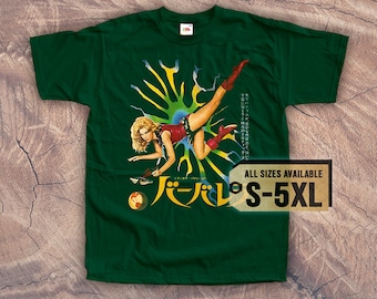 May include: A green t-shirt with a graphic print of a woman in a red and black outfit, kicking her legs up in the air. The graphic is surrounded by a yellow and green design. The text "パピヨン" is printed in white on the shirt. The text "ALL SIZES AVAILABLE S-5XL" is printed on a brown tag.