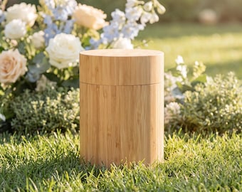 May include: A cylindrical container crafted from light-colored bamboo wood, featuring a smooth, vertical grain pattern and a matching lid that sits flush with the body, creating a seamless, uniform appearance for this simple storage vessel.