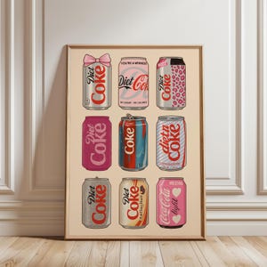 May include: A framed print featuring nine stylized Diet Coke and Coca-Cola cans in various designs. The cans include a pink bow, leopard print, and text like "You're a Winner!" and "Coca-Cola light". The artwork is set against a beige background.
