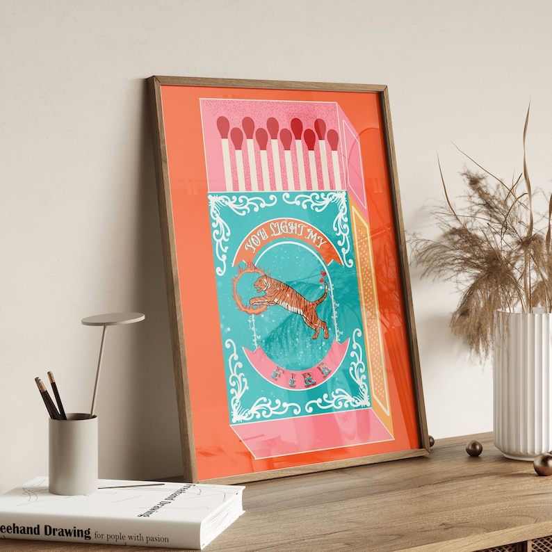 May include: A vintage-style matchbox illustration with a tiger jumping through a ring of fire. The text on the box reads "You light my fire".