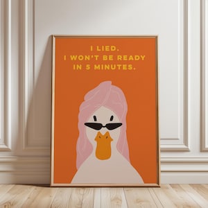 Könnte beinhalten: Orangefarbener Kunstdruck mit einer humorvollen Illustration einer Person mit Entenschnabel, Sonnenbrille und einem rosa Handtuch auf dem Kopf. Der Text lautet: "I LIED. I WON'T BE READY IN 5 MINUTES."