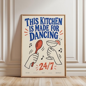 Peut inclure: Une affiche murale rectangulaire sur fond crème avec le texte bleu THIS KITCHEN IS MADE FOR DANCING. En dessous, deux mains tiennent une cuillère en bois rouge et un verre à cocktail avec une tranche d'agrume. Le texte rouge indique 24/7.