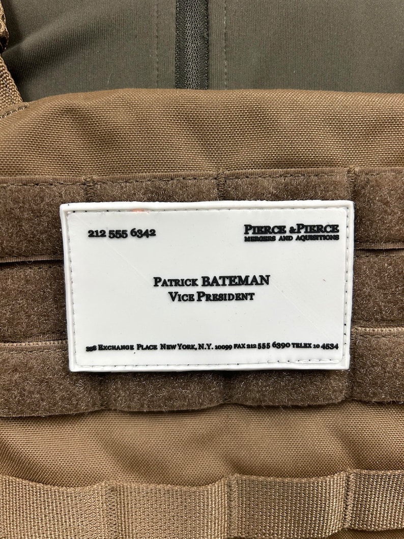 K&ouml;nnte beinhalten: Eine wei&szlig;e Visitenkarte mit schwarzem Text. Die Karte lautet "Pierce & Pierce, Mergers and Acquisitions, Patrick Bateman, Vice President, 388 Exchange Place New York, N.Y. 10099 Fax 212 555 6390 Telex 10 4534".
