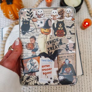 May include: A clear phone case with a collage of Halloween-themed images. The design includes an owl, a black cat, ghosts, pumpkins, bats, and the words "Trick or Treat" and "Extra Spooky Books".