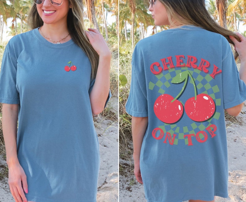 May include: A blue t-shirt with a cherry graphic on the front and the text "CHERRY ON TOP" on the back.