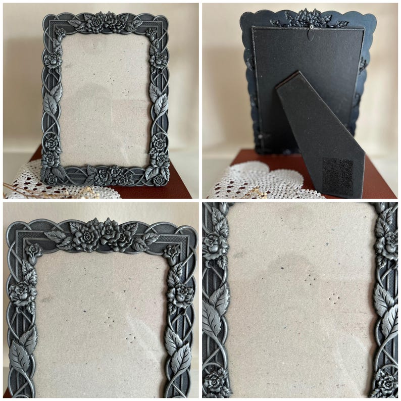 May include: A rectangular, ornate silver-colored picture frame. The frame is decorated with detailed floral and leaf designs. The back of the frame has a black easel stand for display. The frame is designed to hold a photograph or artwork.