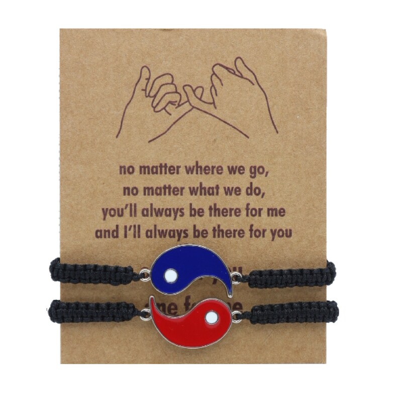 May include: Two black friendship bracelets with yin yang charms. The charms are silver with blue and red enamel. The bracelets are tied together with a knot. The card reads: "no matter where we go, no matter what we do, you'll always be there for me and I'll always be there for you."
