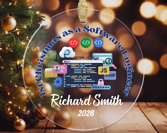 May include: A clear circular ornament featuring the text 1st Christmas as a Software Engineer, Richard Smith, and 2026. The design includes colorful coding icons, a computer screen with code, a cloud, a lock, and various software labels.