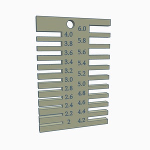 May include: A metal gauge with a hole at the top and markings in increments of 0.2 inches from 2.0 to 6.0 inches.