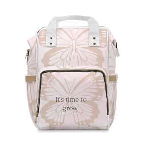 Puede incluir: Una mochila rosa y beige con un patrón de mariposa y el texto "It's time to grow".