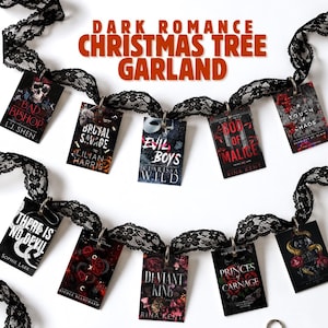 May include: A black lace garland featuring miniature book covers from dark romance novels attached with metal rings. The text reads DARK ROMANCE CHRISTMAS TREE GARLAND and PRE-ASSEMBLED WITH RINGS *SET OF 50*. Includes a pile of loose metal rings.