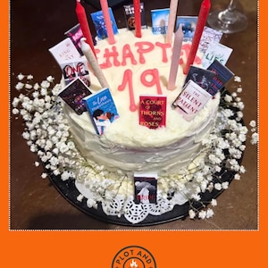 Peut inclure: Un g&acirc;teau rond d&eacute;cor&eacute; de gla&ccedil;age blanc, orn&eacute; de couvertures de livres miniatures et de bougies. Le g&acirc;teau porte l'inscription "CHAPTER 19" en gla&ccedil;age rose. Des fleurs blanches et une nappe d&eacute;corative entourent la base. Un g&acirc;teau pour les lecteurs.