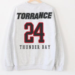 May include: Gray sweatshirt with black text that reads "TORRANCE" and "THUNDER BAY" with a black number "24" in red outlined font.