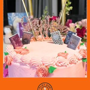 Peut inclure: Un g&acirc;teau rose d&eacute;cor&eacute; de tourbillons de gla&ccedil;age roses et de d&eacute;corations de livres miniatures. Un cake topper en or rose indique "Chapitre 30". Le g&acirc;teau est entour&eacute; de fleurs et de bougies.
