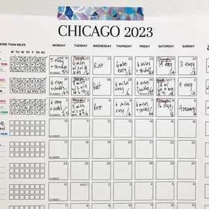 May include: A black and white calendar with the title "CHICAGO 2023" and a weekly mileage tracker. The calendar is filled with handwritten notes about running and strength training workouts.