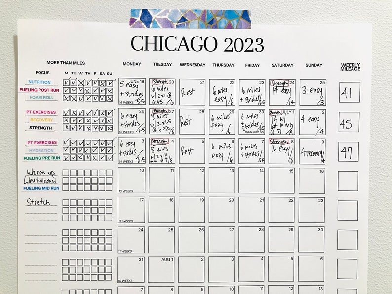 May include: A black and white calendar with the title "CHICAGO 2023" and a weekly mileage tracker. The calendar is filled with handwritten notes about running and strength training workouts.