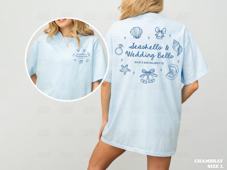K&ouml;nnte beinhalten: Hellblaues T-Shirt mit dem Text "Seashells & Wedding Bells" und zugeh&ouml;rigen Grafiken. Das Shirt hat auch den Text "Julie's Bachelorette" und ist Gr&ouml;&szlig;e L.