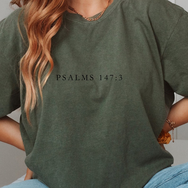以下が含まれることがあります： 前面に「PSALMS 147:3」とプリントされた緑色のTシャツです。