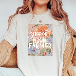 May include: A white t-shirt with a floral print and the text "Support Your Local Flower Farmer" in white.
