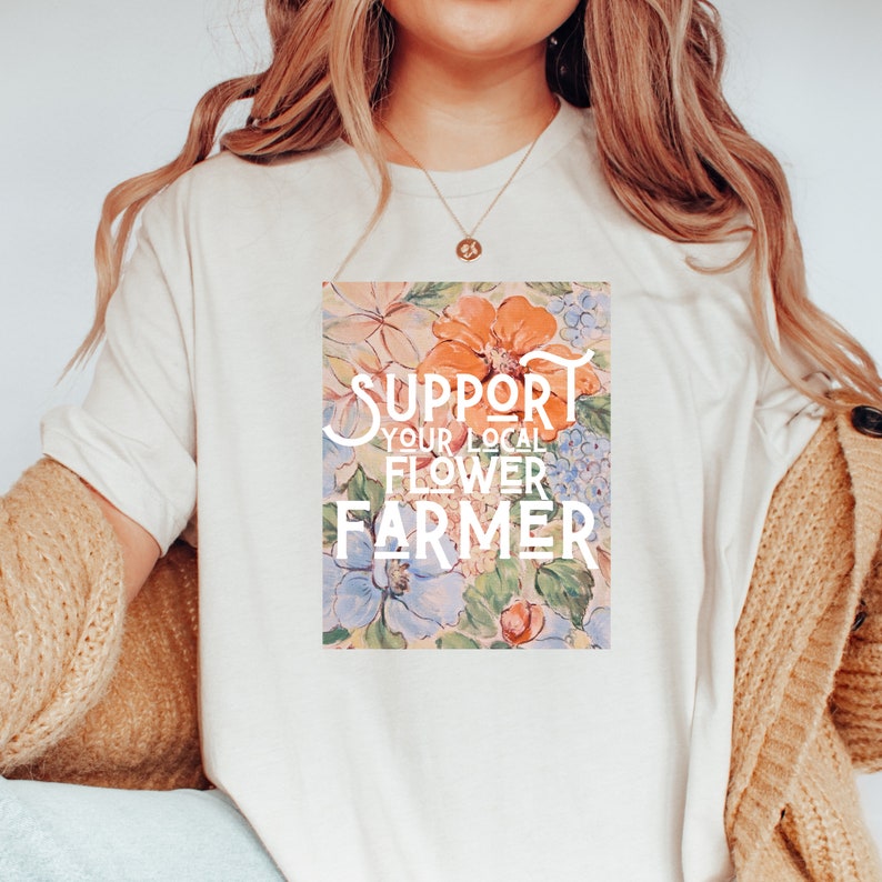 May include: A white t-shirt with a floral print and the text "Support Your Local Flower Farmer" in white.