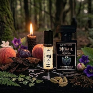 May include: A perfume oil roller bottle and a square glass perfume bottle labeled Hekate by Spiritualist Sanctuary. The labels list notes of peach, plum, peony, violet, leather, patchouli, vanilla, and musk. The bottles are arranged with fruit, flowers, and spices.