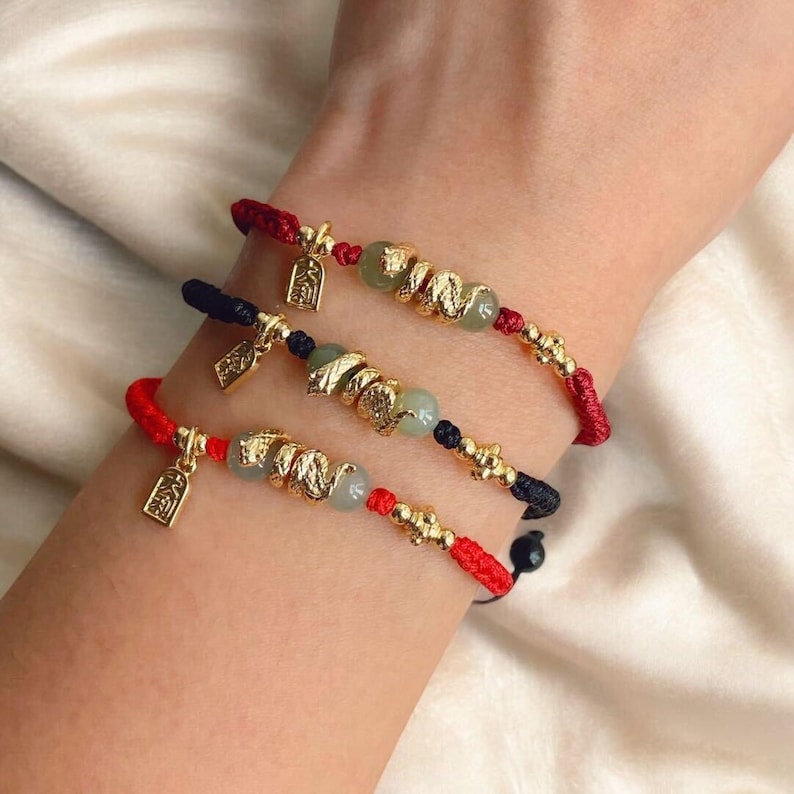 Three snake themed bracelets on a wrist