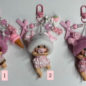 May include: A white ceramic mug with a black handle and the text "But First, Coffee" in a black, handwritten-style font. The mug is on a white surface.