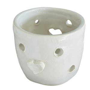 May include: White ceramic planter with a heart-shaped cutout and a small heart-shaped embellishment. The planter has several small holes around the sides.