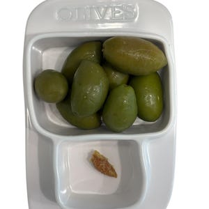 May include: A white ceramic mug with a black handle and the text "But First, Coffee" in a handwritten style. The mug is on a white surface. The mug is approximately 4 inches tall.