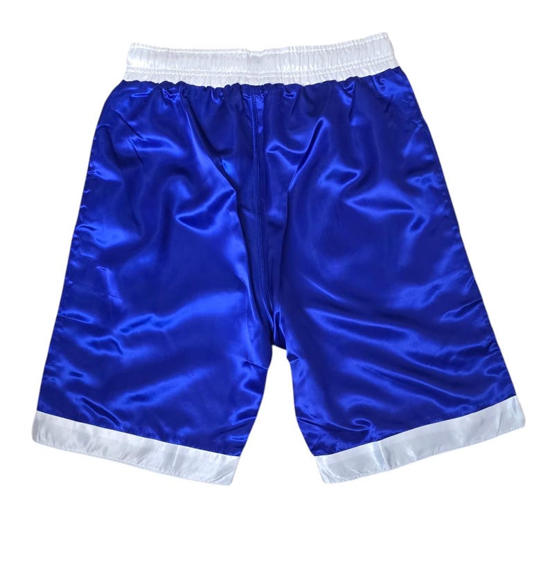 K&ouml;nnte beinhalten: Blaue Satin-Boxershorts mit wei&szlig;em Besatz an Bund und Bein&ouml;ffnungen.