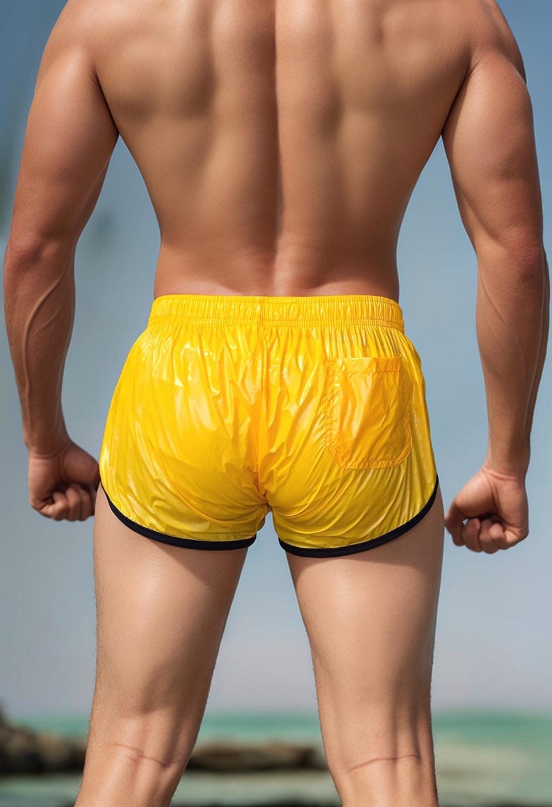 Op de afbeelding: Felge gele sportbroek met een zwarte bies. De short heeft een enkele zak aan de achterkant en is gemaakt van een glanzend, lichtgewicht materiaal. De short wordt van achteren getoond.