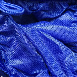 May include: A pair of bright blue athletic shorts featuring a fine mesh lining throughout the interior. The garment includes a gathered elastic waistband with a matching blue drawstring cord visible at the top edge of the fabric.