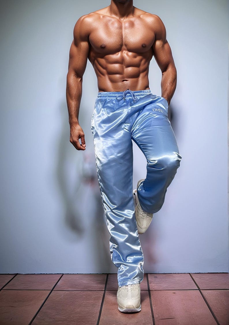 May include: Light blue satin pants with a drawstring waist and the letters "DMW" on the left leg. The pants are paired with white sneakers. The image shows athletic wear.