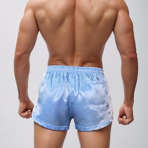 Puede incluir: Pantalones cortos de sat&eacute;n azul claro con rayas laterales blancas. Los pantalones cortos tienen un peque&ntilde;o bolsillo trasero y una cintura con cord&oacute;n. La tela tiene un ligero brillo, d&aacute;ndole un aspecto sedoso. Dise&ntilde;ado para actividades deportivas.