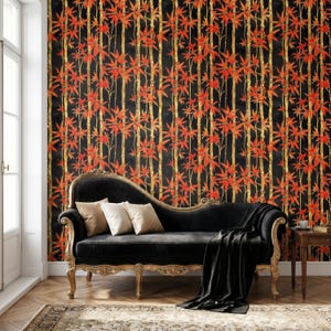 Puede incluir: Una chaise longue de terciopelo negro con respaldo curvo y marco de madera dorada ornamentada, con dos cojines beige y una manta negra, frente a un papel tapiz con un patr&oacute;n repetitivo de tallos de bamb&uacute; dorados y hojas rojas.
