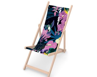 Puede incluir: Una silla de playa de madera con un asiento de tela azul oscuro con un estampado floral tropical con orquídeas rosas, hojas verdes y colibríes.